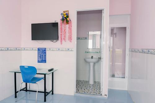 baño con aseo y TV en la pared en Phương Tú Hostel, en Xuyên Mộc