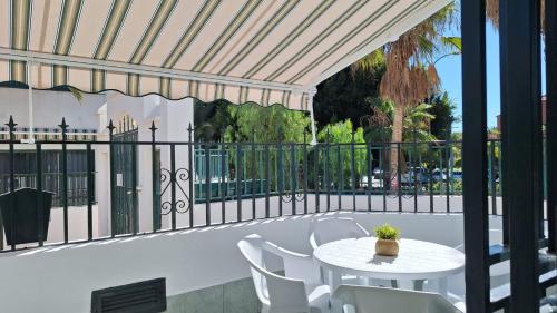 patio ze stołem, krzesłami i ogrodzeniem w obiekcie FRANCY PLACE w mieście Costa Del Silencio