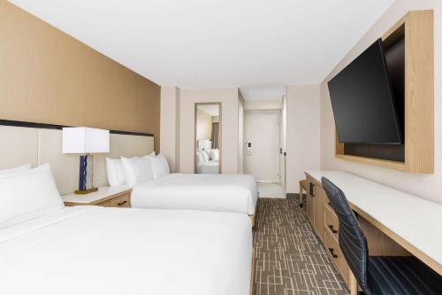 a hotel room with two beds and a flat screen tv at DoubleTree by Hilton Charlotte City Center in Charlotte