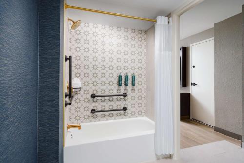 a bathroom with a shower with a white tub at DoubleTree by Hilton Charlotte City Center in Charlotte
