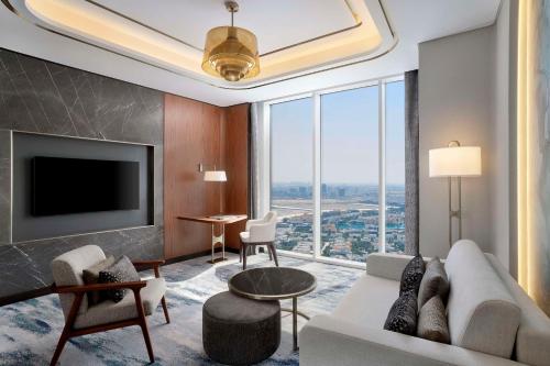 a living room with a couch and a tv at Embassy Suites By Hilton Dubai Business Bay in Dubai