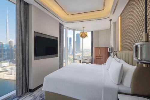 a hotel room with a bed and a large window at Embassy Suites By Hilton Dubai Business Bay in Dubai