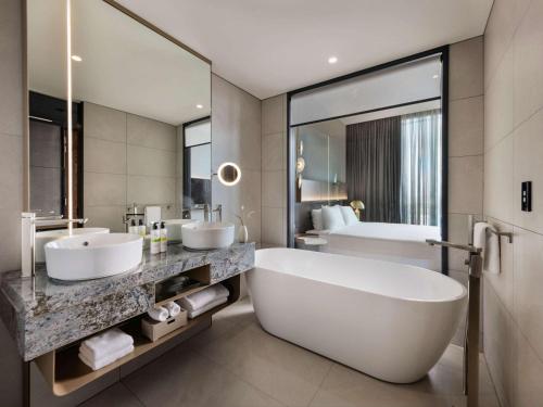 a bathroom with two sinks and a large tub at Pullman Auckland Airport in Auckland