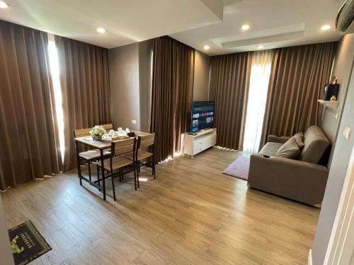 a living room with a couch and a table at The Blu X Family grand Suite in Ban Bang Saen (1)