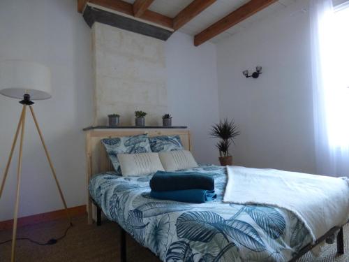 a bedroom with a bed with blue and white sheets at La Patte Charentaise Parking gratuit Le calme en ville in Saintes