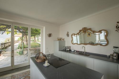 a kitchen with a sink and a mirror on the wall at Villa Intreccio in Blevio