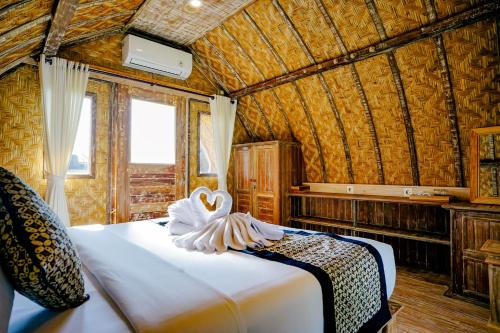 un dormitorio con una cama con una decoración de cisne en Alvia Joglo House & Private Pool en Tampaksiring