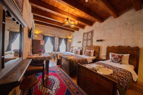 1 dormitorio con 4 camas en una habitación con techos de madera en Safran Cave Hotel, en Göreme