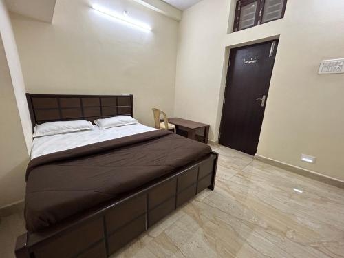 a bedroom with a large bed and a black door at The kaya homestay Srirangam in Srīrangam