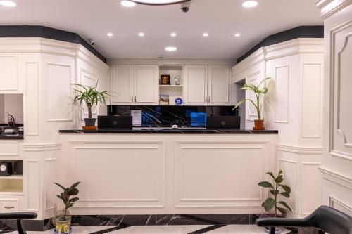 a large white kitchen with white cabinets and plants at AMASRA DADAYLI HOTEL in Amasra