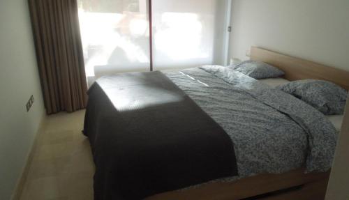 a bedroom with a bed in a room with a window at Jardines de Albaicin - La Aldorra in Estepona