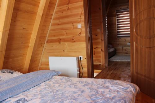 a bedroom with a bed in a wooden cabin at Three Houses in Žabljak