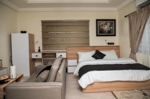 1 dormitorio con 1 cama y 1 sofá en Deisberry court, en North Legon