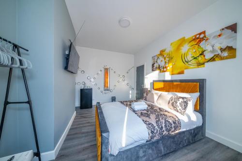 a bedroom with a bed and a painting on the wall at *RD12s* For your most relaxed & Cosy stay + Free Parking + Free Fast WiFi * in Headingley