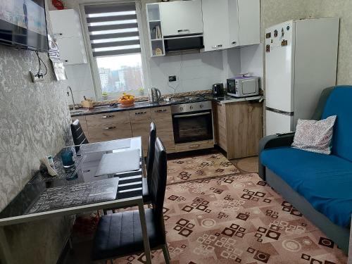 a small kitchen with a table and a refrigerator at Apartament confortabil in Chişinău