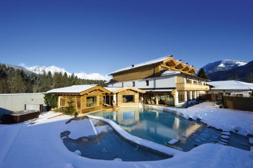 a house with a swimming pool in the snow at Franzlhof in Söll