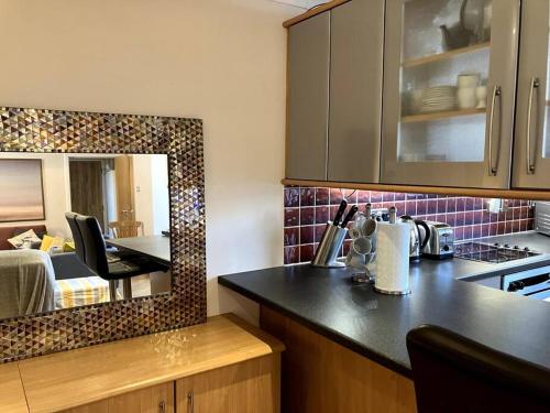 a kitchen with a counter top and a room with a bed at Bright central large cosy flat in Fife