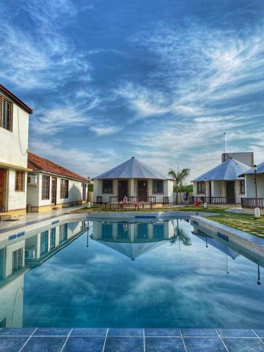 a large swimming pool in front of a house at The Village Resort in Kodāe