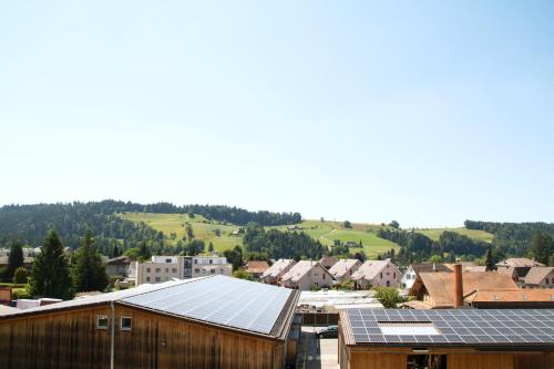 un grupo de paneles solares en los tejados de edificios en Geräumige und stylische Wohnung mit Weitsicht, en Huttwil
