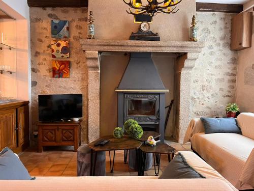 a living room with a fireplace and a tv at Maison Mayeras, 3 ch in Razès