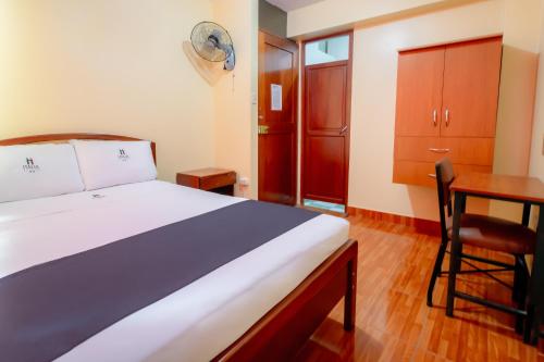 a bedroom with a bed and a desk and a chair at Hotel Italia II in Chiclayo