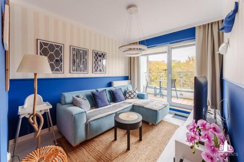 uma sala de estar azul com um sofá azul em 3L Apartments Nadmorskie Tarasy em Kolobrzeg