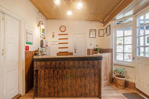 Treebo The Alpine Heritage Residency في شيملا: بار في غرفة مع جدار خشبي