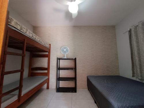 a bedroom with two bunk beds and a fan at Casa de Praia in Ubatuba