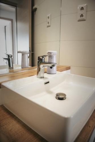 a bathroom sink with a faucet and a mirror at Nádas Apartman in Szeged