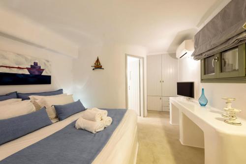 a white and blue bedroom with a bed and a desk at Hotel Senia - Onar Hotels Collection in Naousa