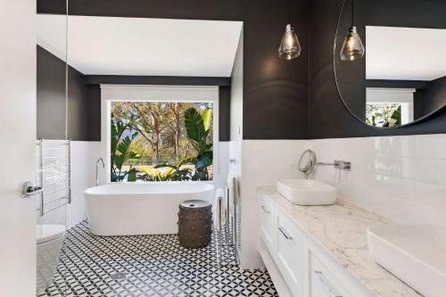 y baño con 2 lavabos, bañera y espejo. en Braeside, Kangaroo Valley, en Valle Kangaroo