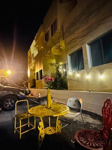 a yellow table and chairs in front of a building at Shi Bi Hotel in Gukeng