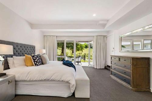 1 dormitorio con 1 cama y vestidor con ventana en Braeside, Kangaroo Valley, en Valle Kangaroo