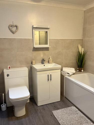 a bathroom with a toilet and a sink and a bath tub at Wharf Cottage in Coalbrookdale