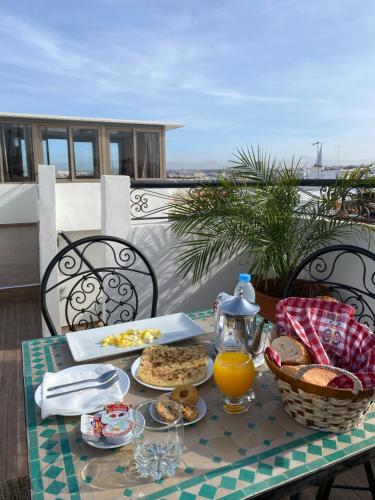 a table with food and orange juice on a balcony at Riad Jbara 2 in Rabat