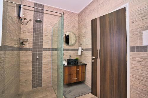 a bathroom with a shower with a sink and a mirror at Sunset Haven Villa in Beau Vallon