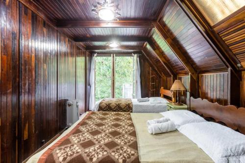 a bedroom with two beds in a room with wooden walls at Chalé inteiro completo a 5 min a pé do Capivari - Campos do Jordão in Campos do Jordão