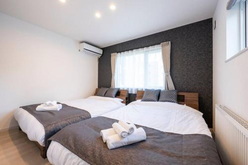 - une chambre avec 2 lits et des serviettes dans l'établissement THE LUNA LOUNGE, à Tsukisappu