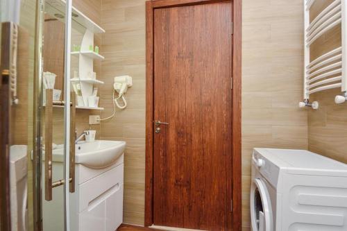 bagno con porta in legno e lavatrice. di Hotel King David Bakuriani a Bakuriani