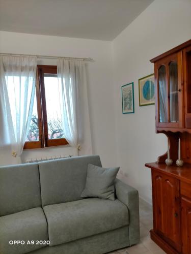 a living room with a couch and a window at Casa LORE in Castelbuono