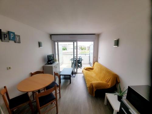 un salon avec une table et un canapé dans l'établissement L'Albatros- Parking - Piscine, à La Rochelle