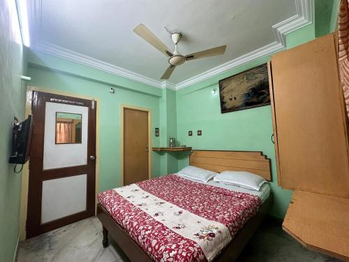 1 dormitorio con 1 cama y ventilador de techo en The Kaya Rockview Trichy, en Tiruchchirāppalli