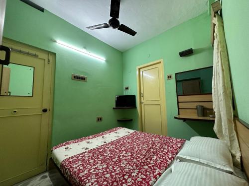 a bedroom with green walls and a bed with a red blanket at The Kaya Rockview Trichy in Tiruchchirāppalli