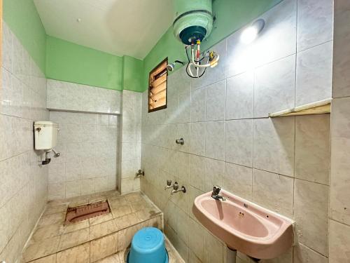 y baño con lavabo y bañera de color rosa. en The Kaya Rockview Trichy, en Tiruchchirāppalli