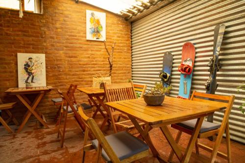 a room with tables and chairs and a skateboard on the wall at Hostel Cosmo in El Bolsón