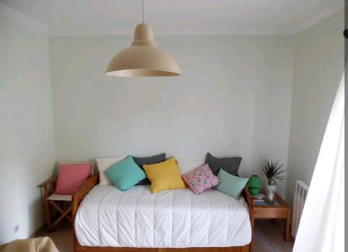 Habitación con cama con almohadas coloridas. en Cozy Beach House, en Santa Cruz