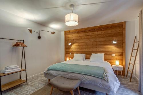 a bedroom with a large bed and a wooden wall at Les Chalets de La Clusaz - Appartement le Yeti in La Clusaz