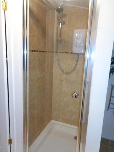 een douche met een glazen deur in de badkamer bij Idyllic Log Cabin Near Stratford upon Avon in Stratford-upon-Avon