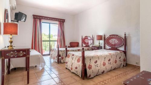 sypialnia z 2 łóżkami, stołem i oknem w obiekcie Hotel Sol e Serra w mieście Castelo de Vide