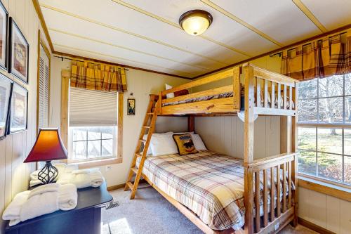 a bedroom with a bunk bed and a desk with a lamp at Pine Woods Cabin in McHenry
